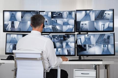 A man looks at security camera screens