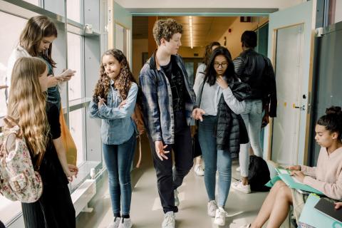 A group of students walking through a school corridor