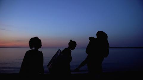 sihouette of family walking next to the sea