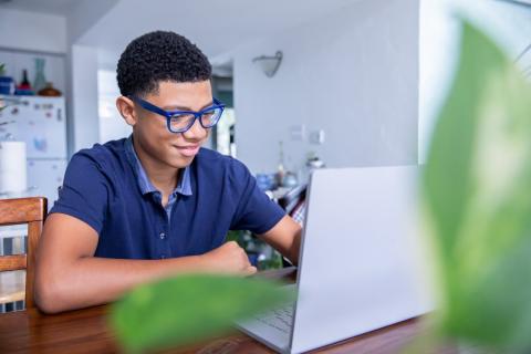 A boy typing on a laptop