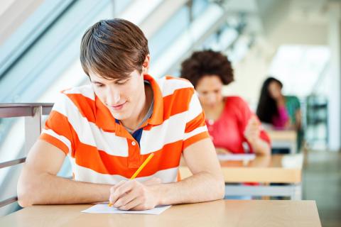 A student writes something on paper