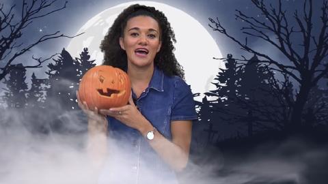 A female presenter holds up a pumpkin