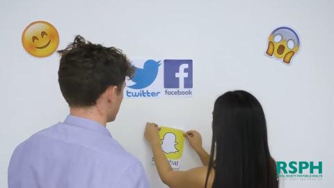 Two people looking at social media icons on a whiteboard