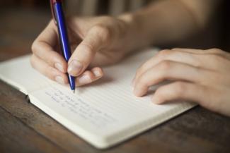 A person writing in a notebook