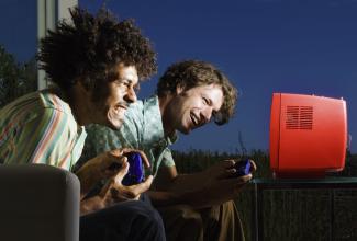 Two young men playing a video game with excited expressions