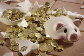 A broken piggy bank with coins spilling out