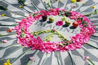 Flowers placed on the ground around the word 'imagine'