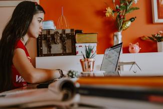 A teen girl browses job adverts on a laptop