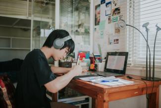 A student writing at a desk