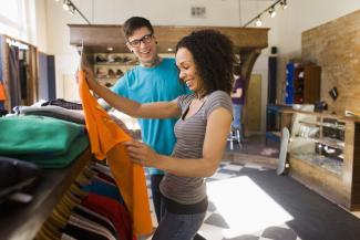 A woman holding a T-shirt in a clothes shop