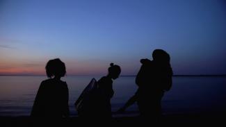 sihouette of family walking next to the sea