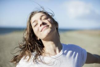 A woman smiling with her eyes closed