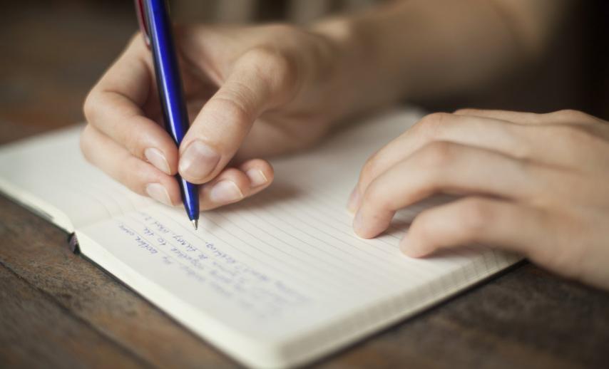 A person writing in a notebook