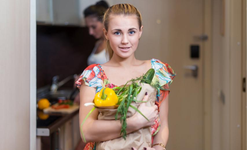 A young woman holding a bag of vegetables
