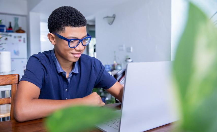 A boy typing on a laptop
